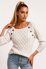 White cable-knit sweater styled with light-wash jeans, chic casual look